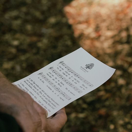 Notenblatt mit Logo in der Hand